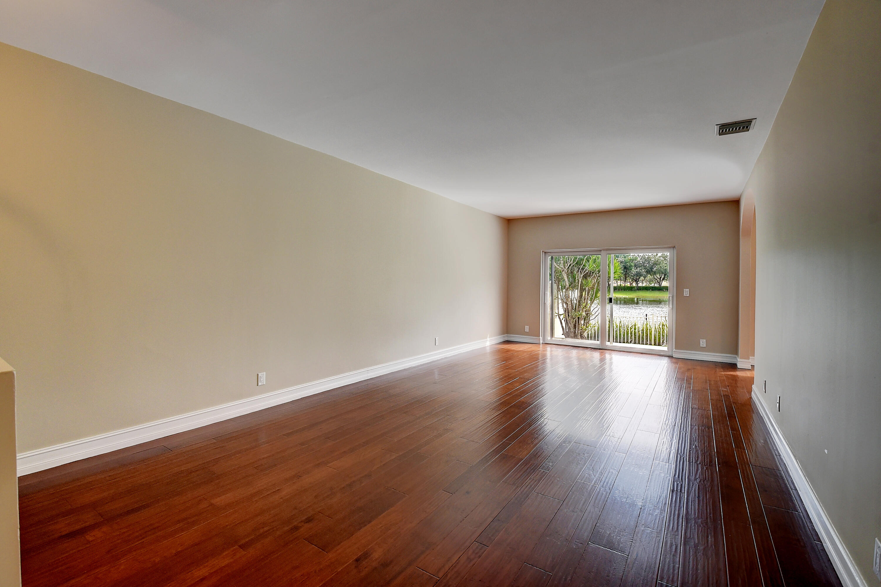10599 Palm Spring Drive Boca Raton, FL 33428 - Photo 6 of 46 a view of an empty room with wooden floor and a window