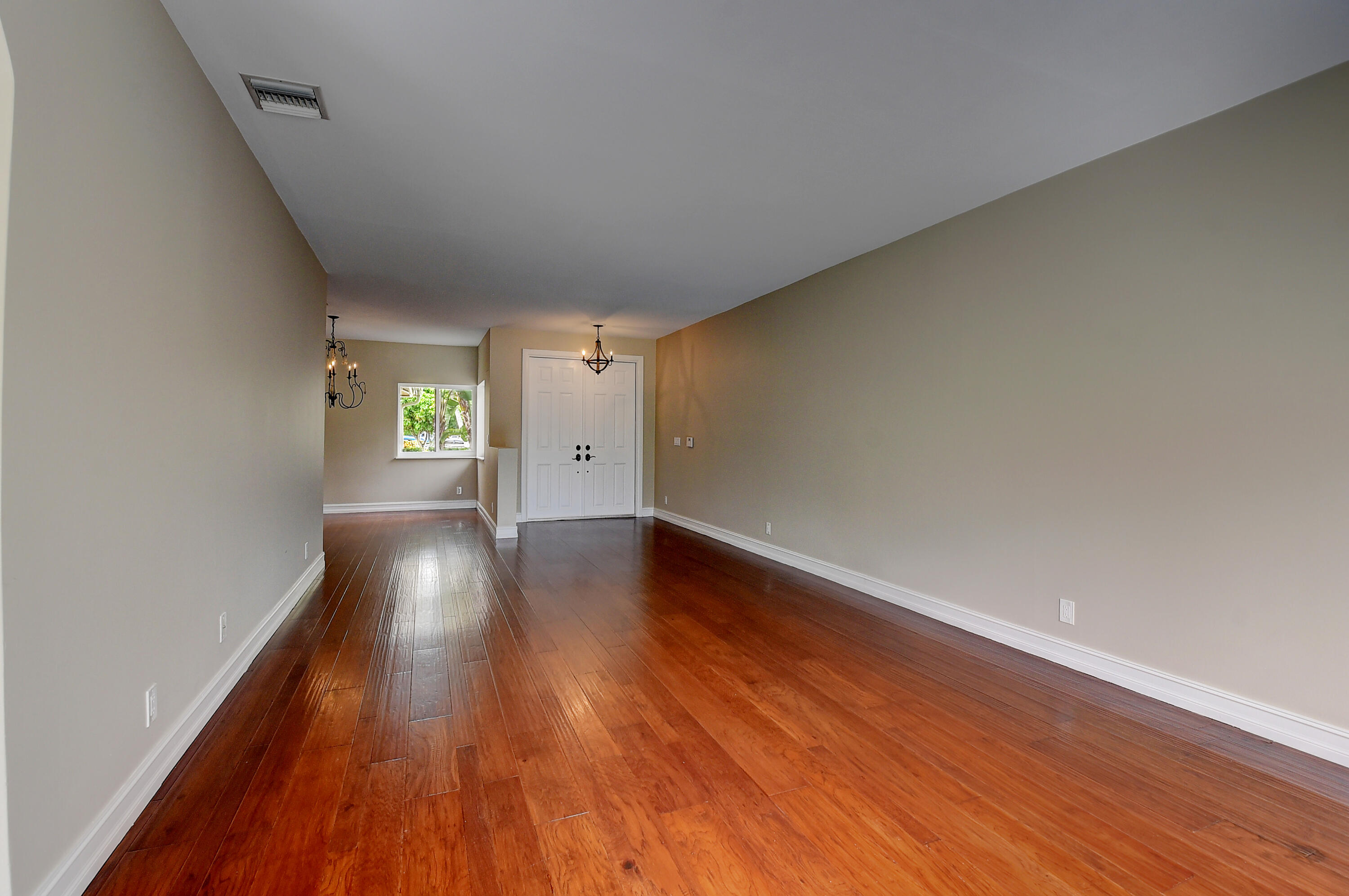 10599 Palm Spring Drive Boca Raton, FL 33428 - Photo 7 of 46 a view of an empty room with wooden floor and a window