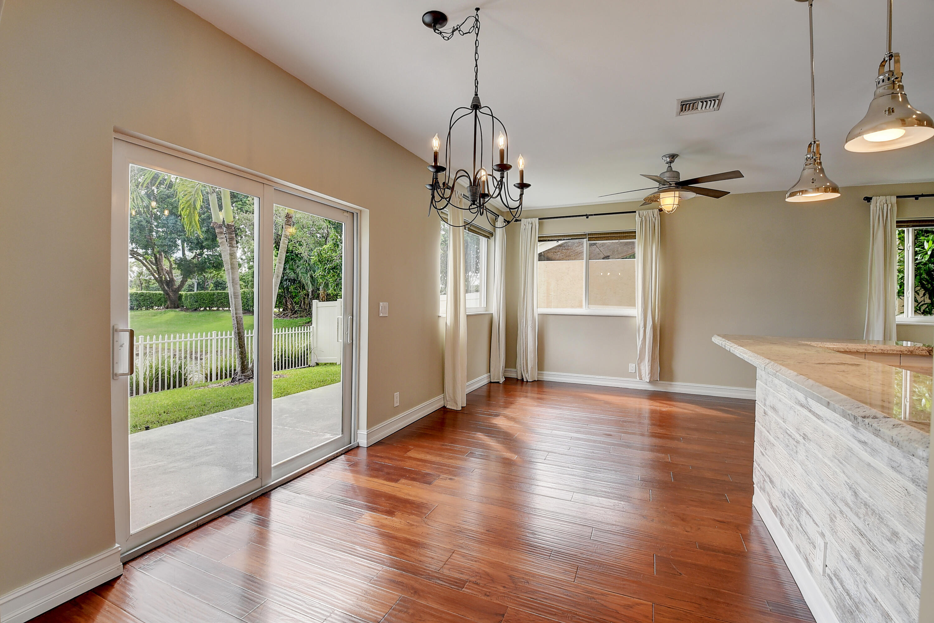 10599 Palm Spring Drive Boca Raton, FL 33428 - Photo 9 of 46 a view of a room with wooden floor chandeliers and kitchen