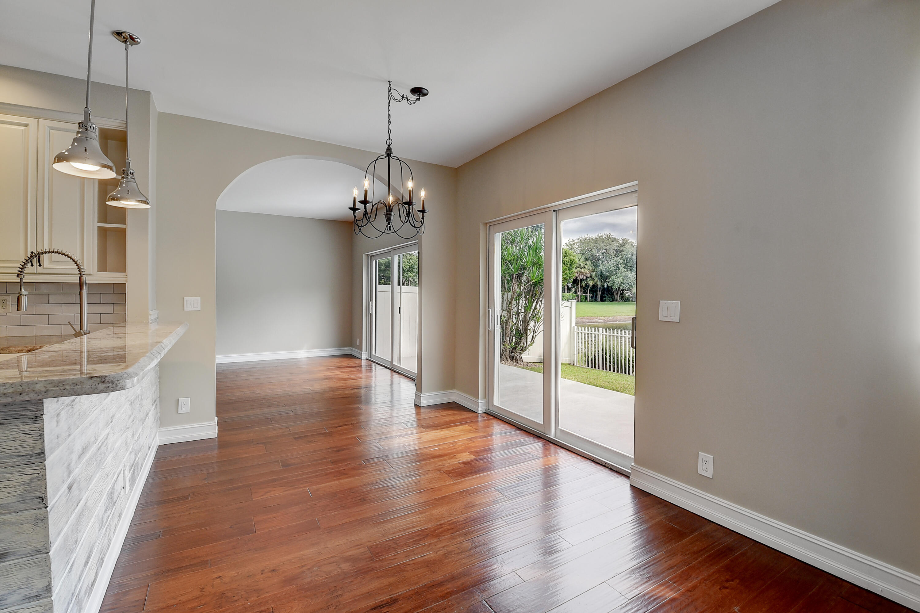 10599 Palm Spring Drive Boca Raton, FL 33428 - Photo 10 of 46 a view of a room with wooden floor chandeliers and kitchen