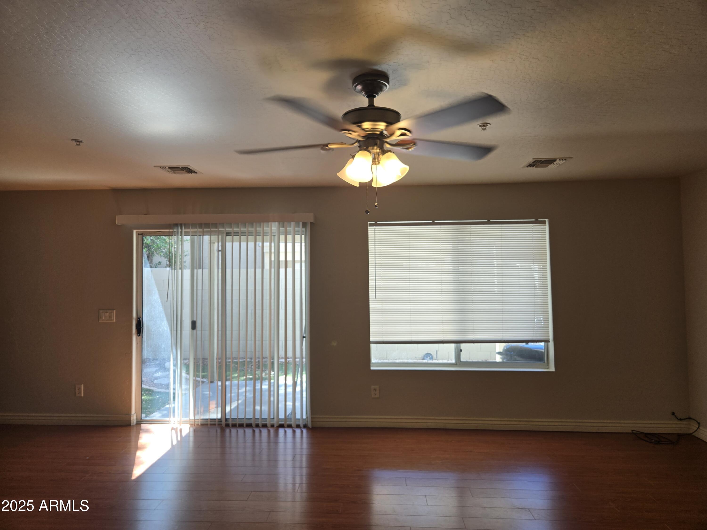 16021 North 30th Street, Unit 119 Phoenix, AZ 85032 - Photo 11 of 28 a view of an empty room with wooden floor and a window