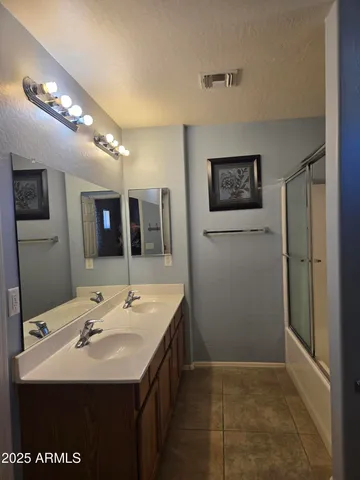 a bathroom with a sink a large mirror and shower