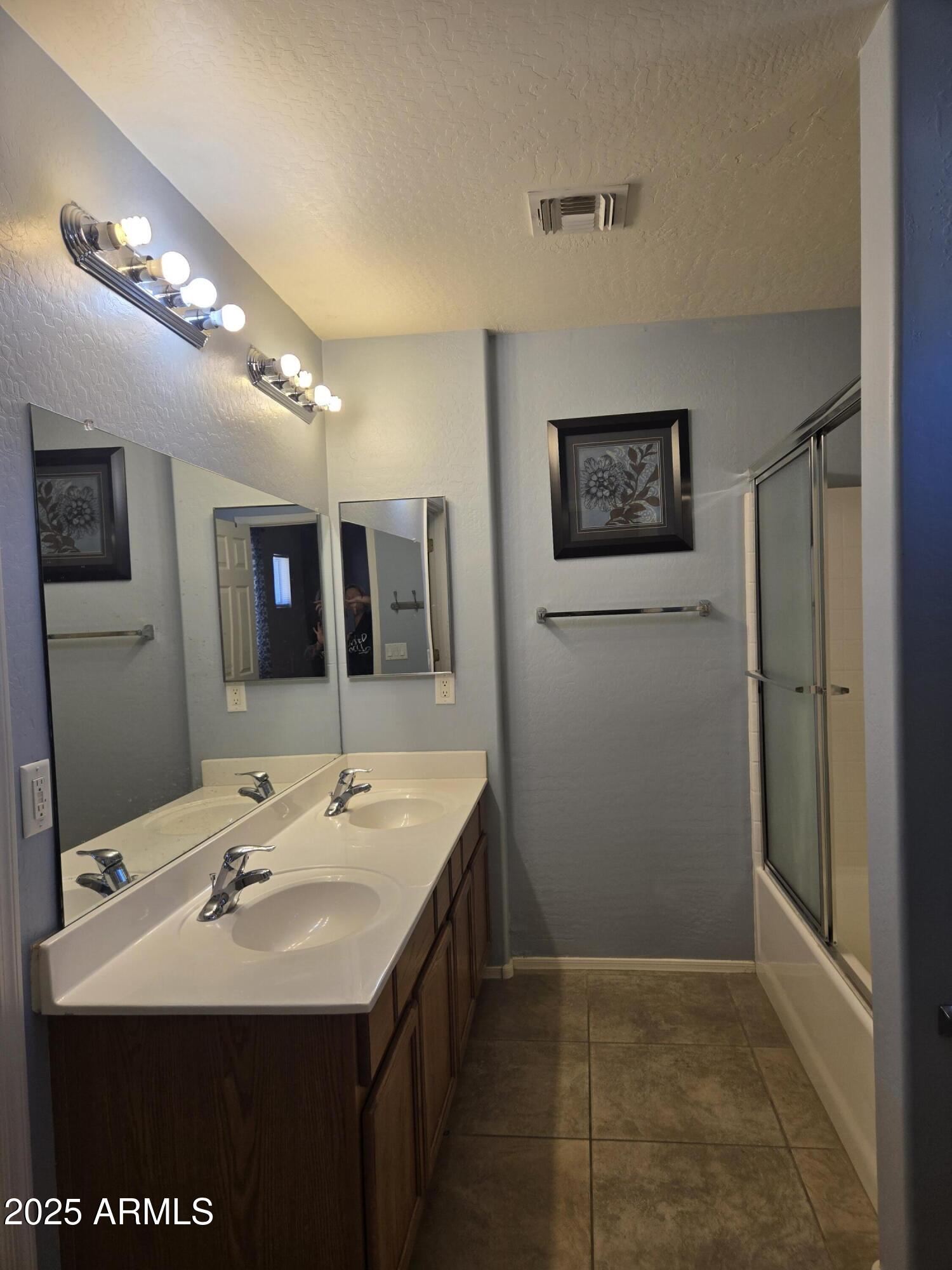 16021 North 30th Street, Unit 119 Phoenix, AZ 85032 - Photo 23 of 28 a bathroom with a sink a large mirror and shower