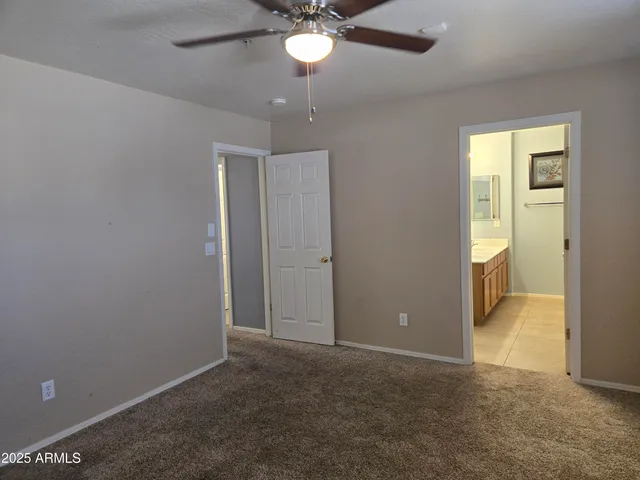 an empty room with closet and a chandelier fan