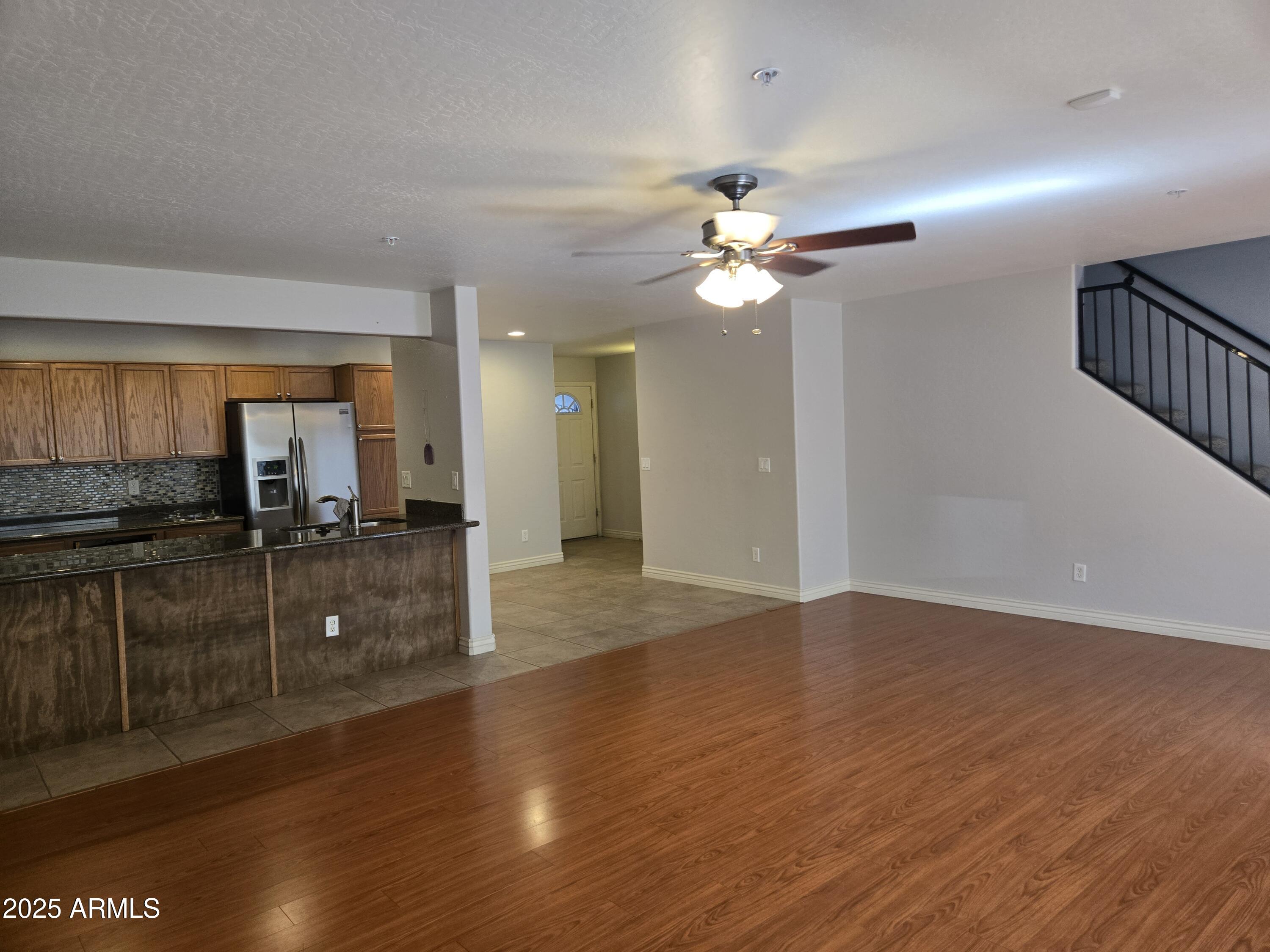 16021 North 30th Street, Unit 119 Phoenix, AZ 85032 - Photo 10 of 28 a view of a kitchen with sink a ceiling fan and wooden floor