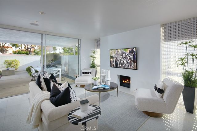 a living room with furniture a fireplace and a large window
