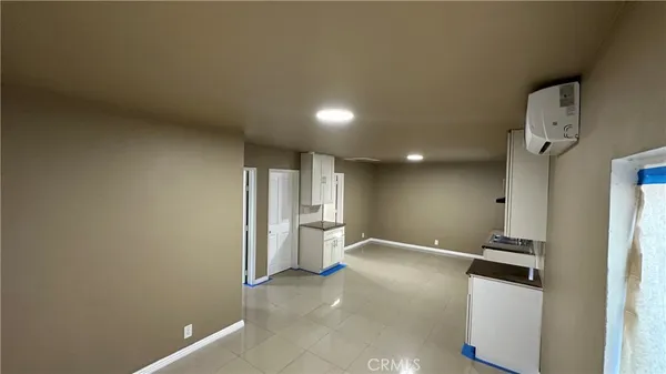 a view of a kitchen with refrigerator and white walls