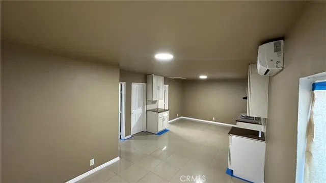 a view of a kitchen with refrigerator and white walls