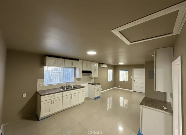 a large white kitchen with a large window
