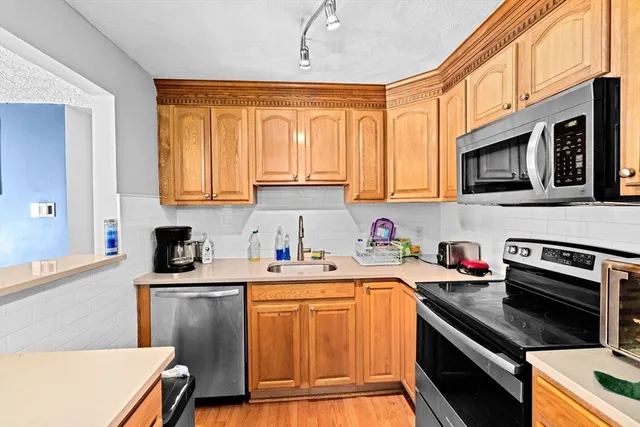 a kitchen with stainless steel appliances a stove sink microwave and cabinets