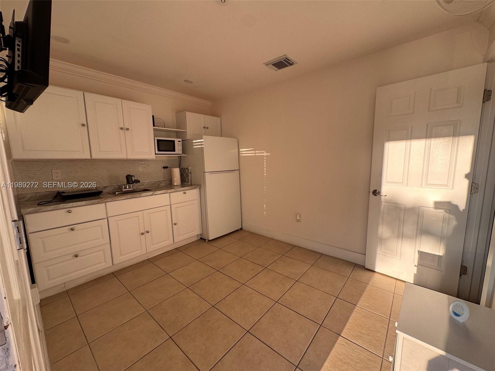 842 Southwest 89th Avenue, Unit B Miami, FL 33174 - Photo 2 of 7 a kitchen with a sink a stove and cabinets