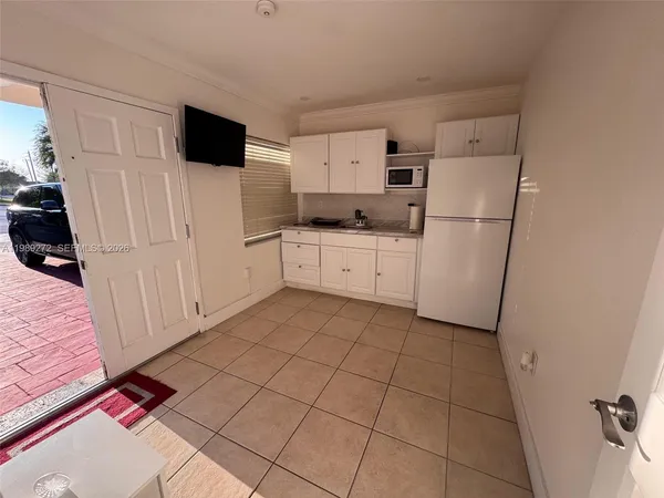a kitchen with white cabinets a refrigerator and a stove
