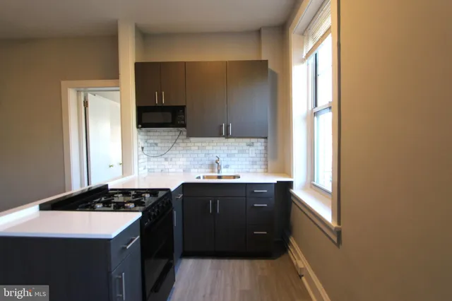a kitchen with a sink and a stove next to a window