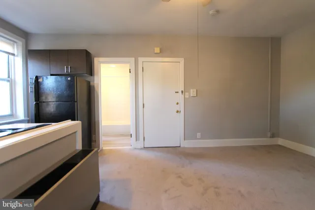a view of empty room with window and refrigerator