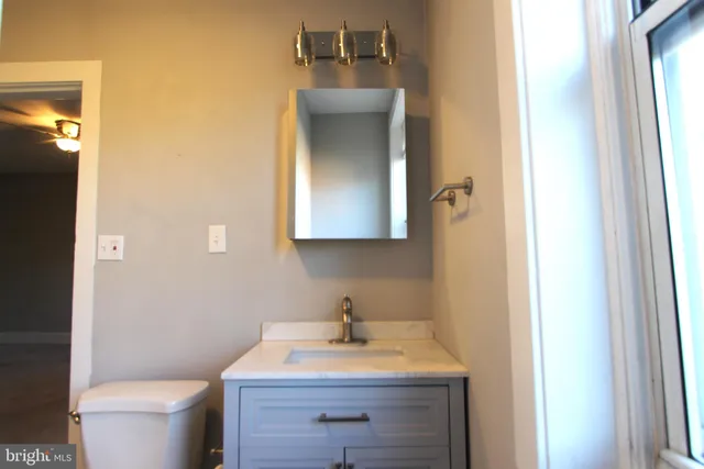 a bathroom with a toilet sink and mirror