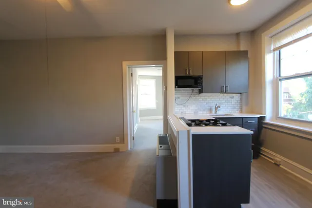 a kitchen with a stove a sink and a window