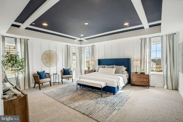 a spacious bedroom with a large bed and a chandelier