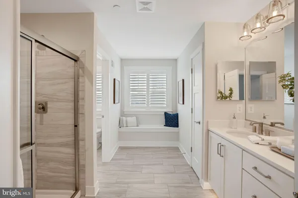 a spacious bathroom with a shower sink and a mirror