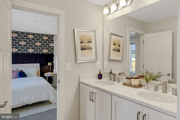 a en suite bathroom with a double vanity sink and a mirror