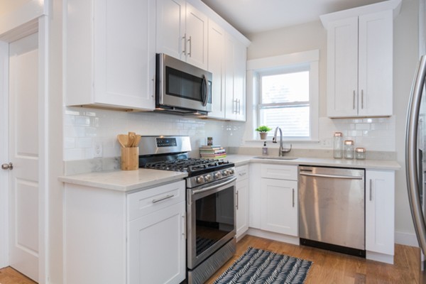 39 Montrose Street, Unit 2 Everett, MA 02149 - Photo 5 of 12 a kitchen with white cabinets stainless steel appliances and sink