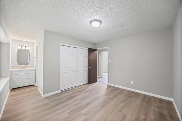 an empty room with wooden floor and mirror