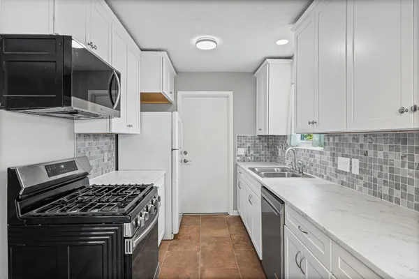 a kitchen with stainless steel appliances a sink a stove and microwave
