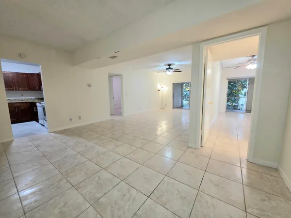 a view of a hallway with wooden floor and a living room