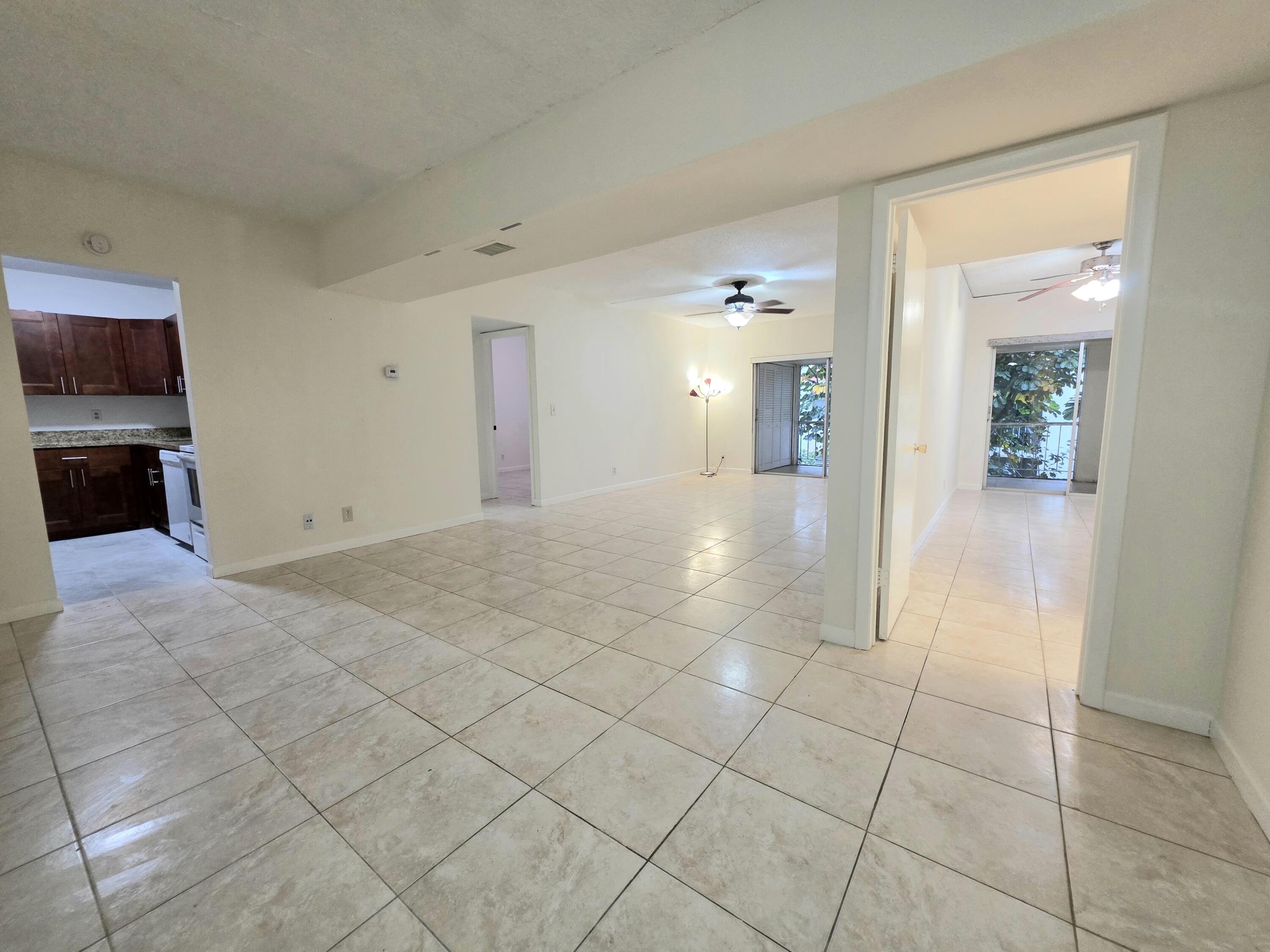 683 Northwest 13th Street, Unit 27 Boca Raton, FL 33486 - Photo 1 of 16 a view of a hallway with wooden floor and a living room