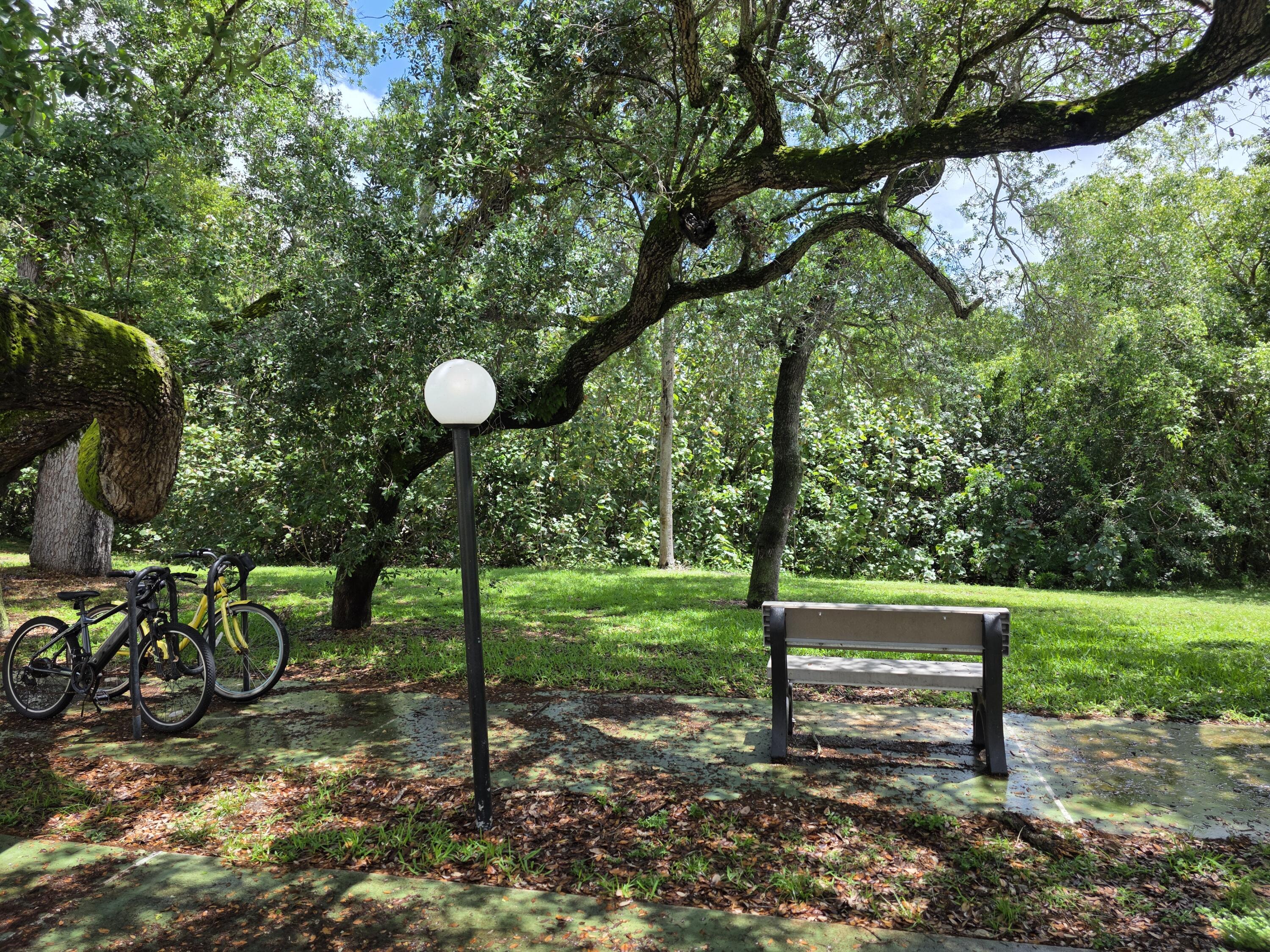 683 Northwest 13th Street, Unit 27 Boca Raton, FL 33486 - Photo 11 of 16 a view of a bench in a garden