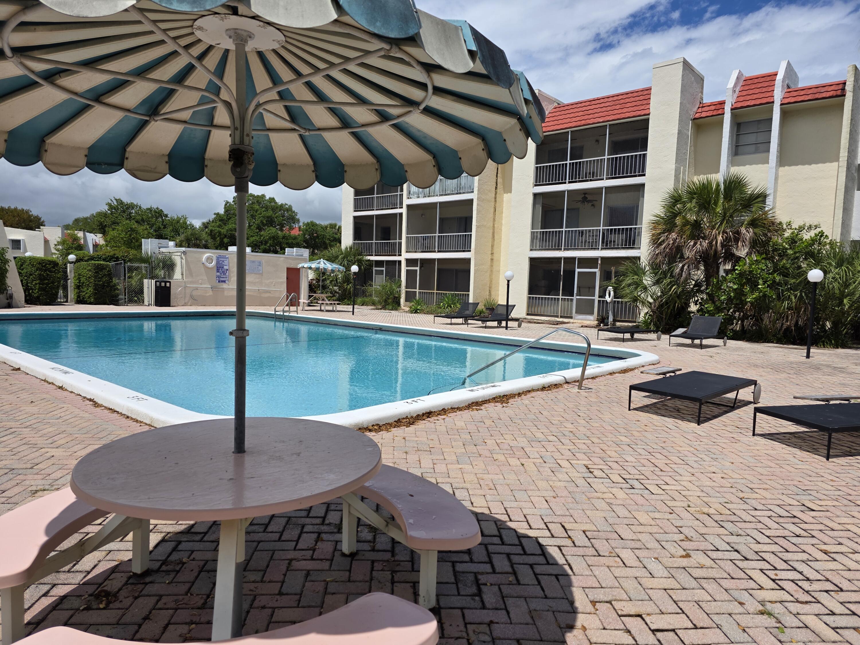 683 Northwest 13th Street, Unit 27 Boca Raton, FL 33486 - Photo 13 of 16 a view of a swimming pool with a lounge chairs