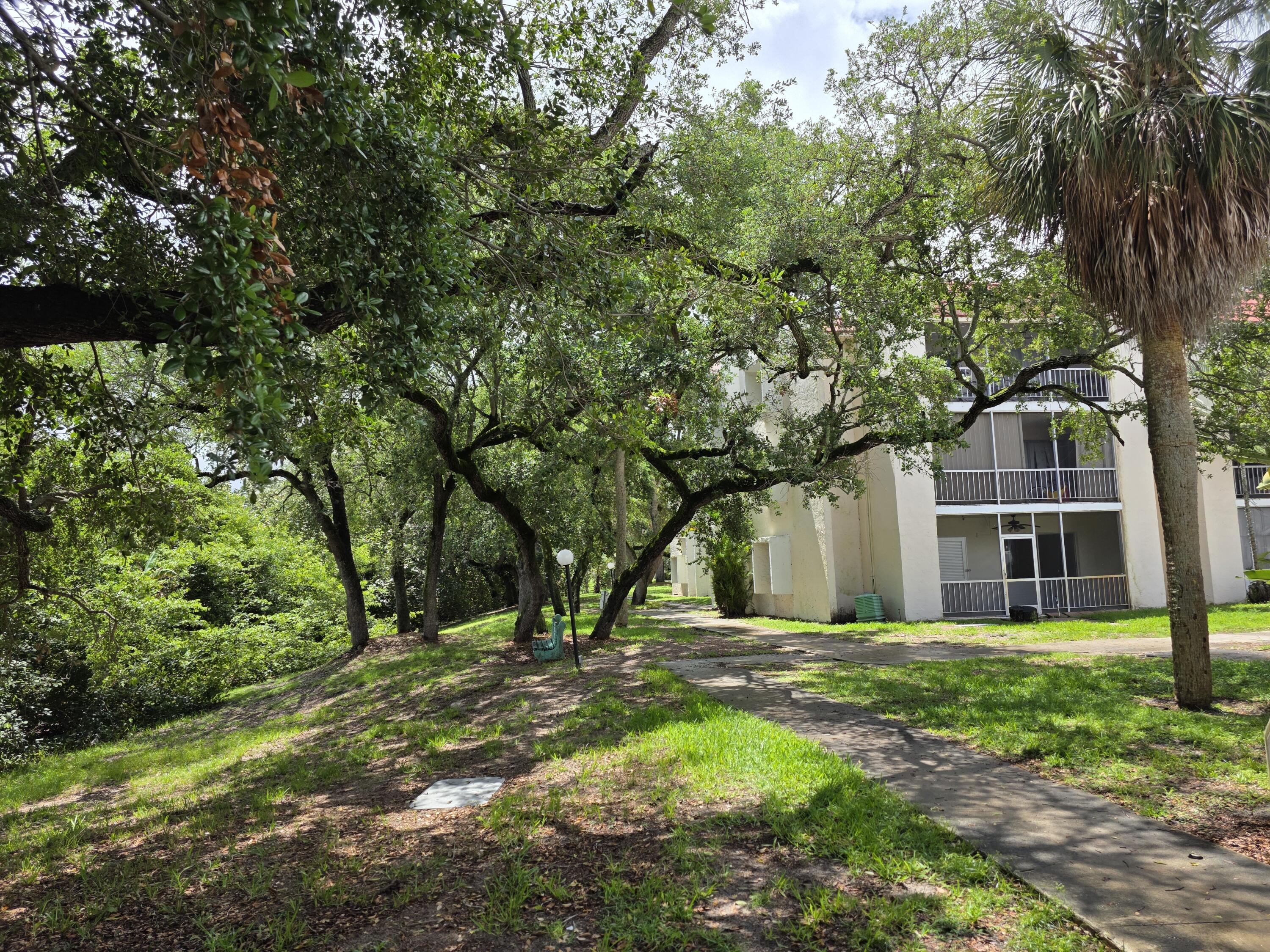 683 Northwest 13th Street, Unit 27 Boca Raton, FL 33486 - Photo 14 of 16 a view of a house with a tree in a yard