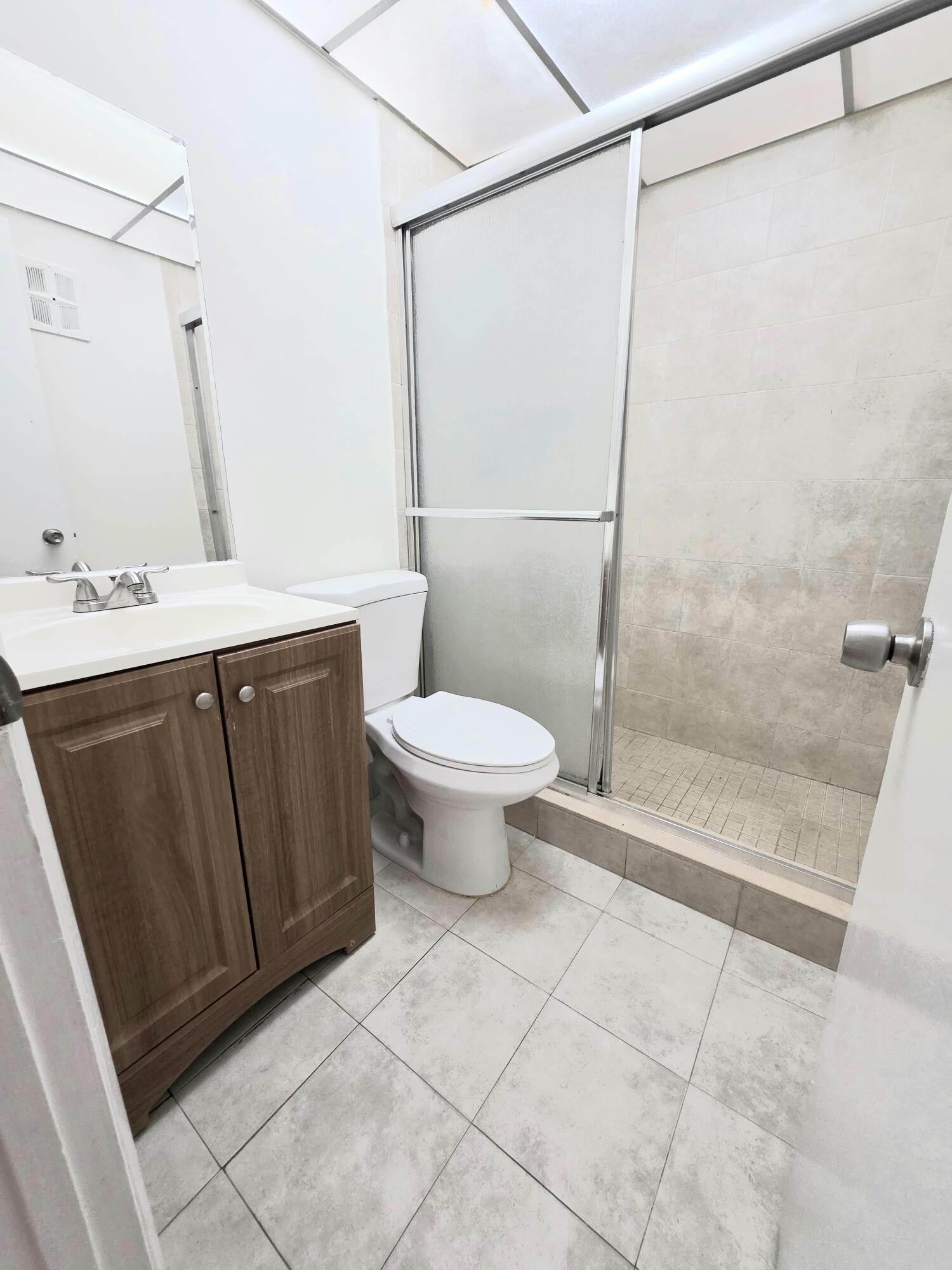 683 Northwest 13th Street, Unit 27 Boca Raton, FL 33486 - Photo 2 of 16 a bathroom with a sink a toilet and shower