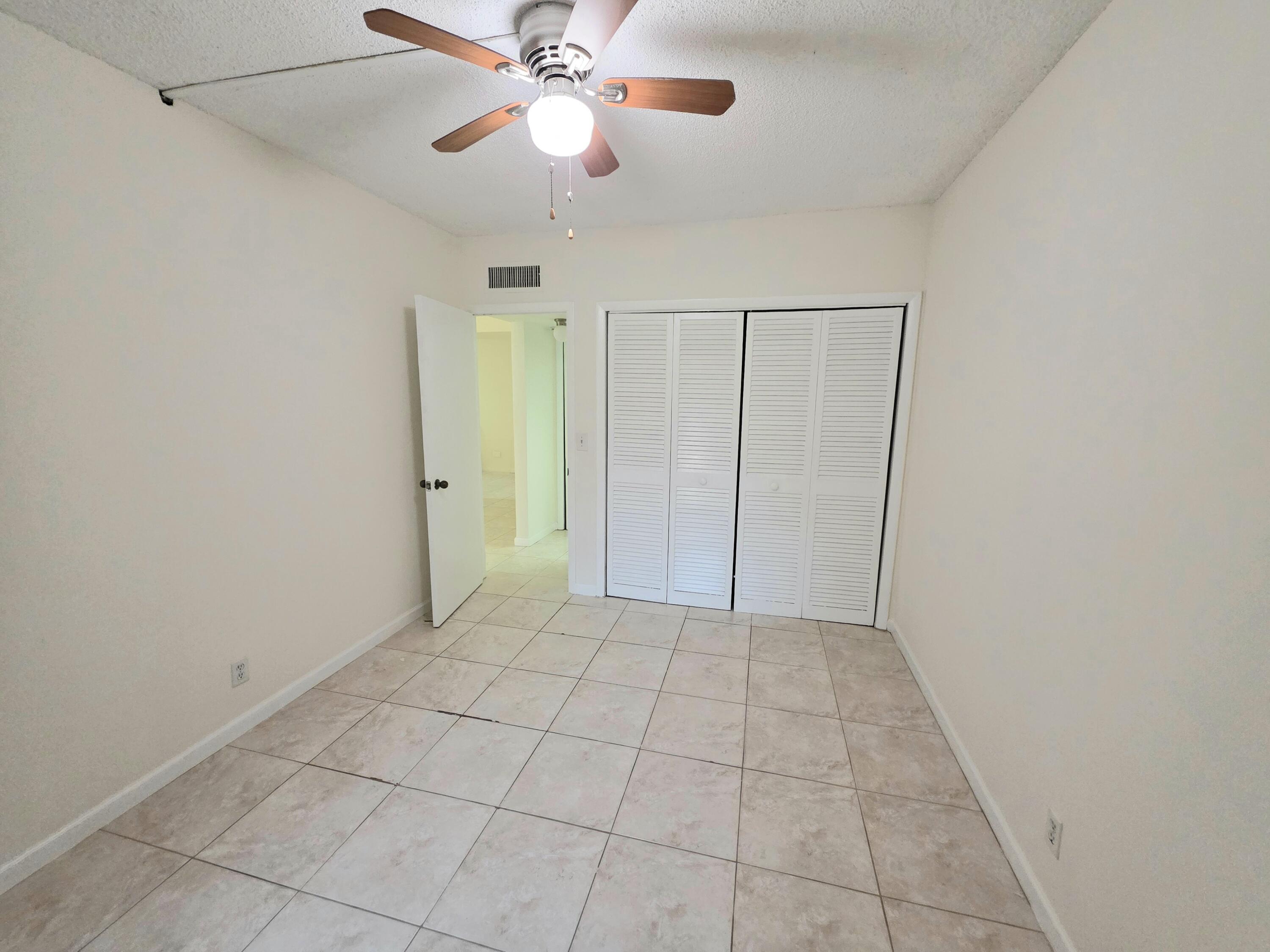 683 Northwest 13th Street, Unit 27 Boca Raton, FL 33486 - Photo 4 of 16 an empty room with a ceiling fan and a shower
