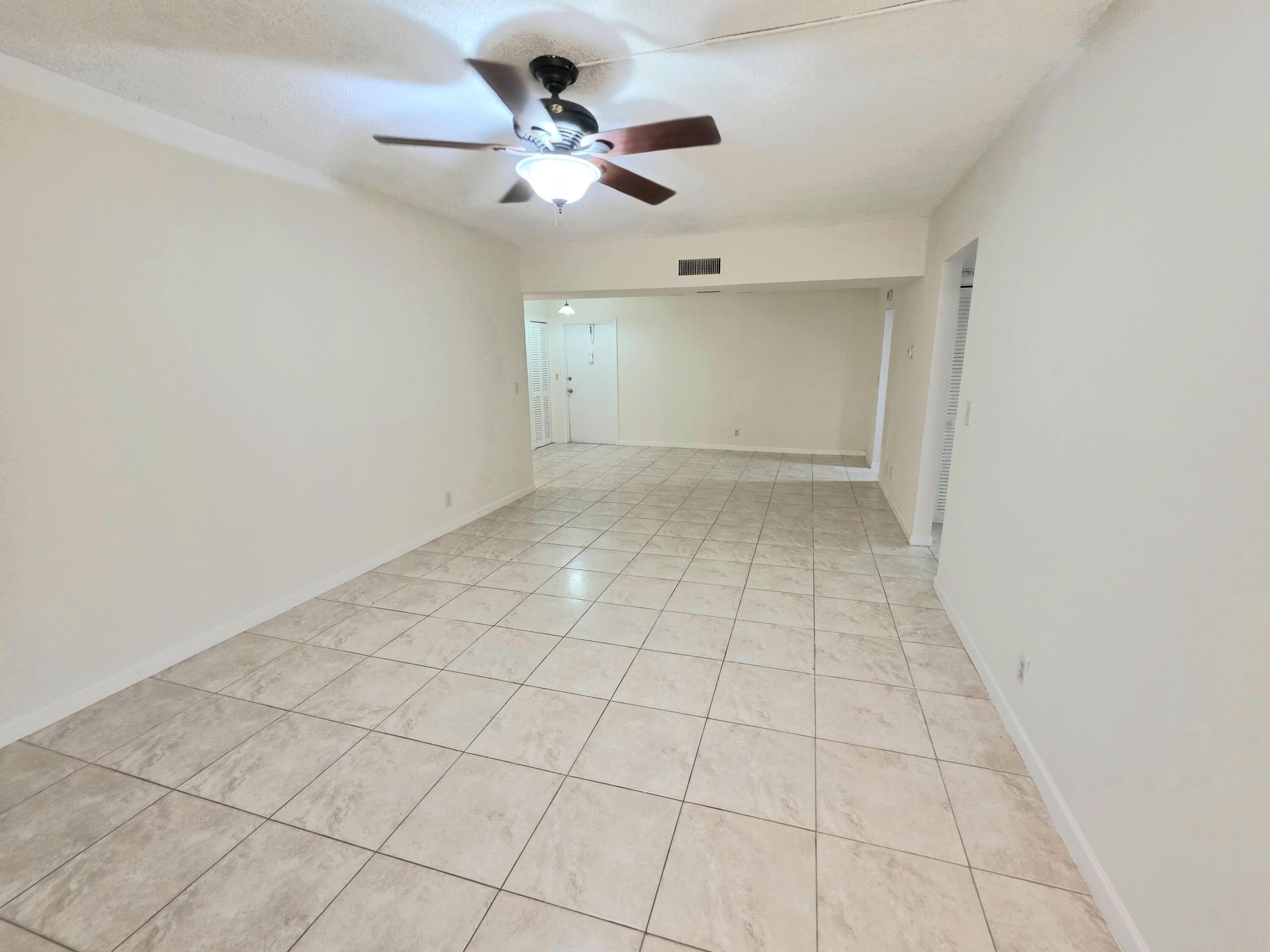 683 Northwest 13th Street, Unit 27 Boca Raton, FL 33486 - Photo 8 of 16 a view of an empty room and a chandelier fan