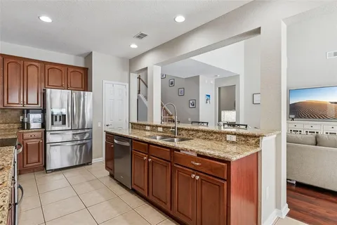 a kitchen with stainless steel appliances granite countertop a sink stove and refrigerator