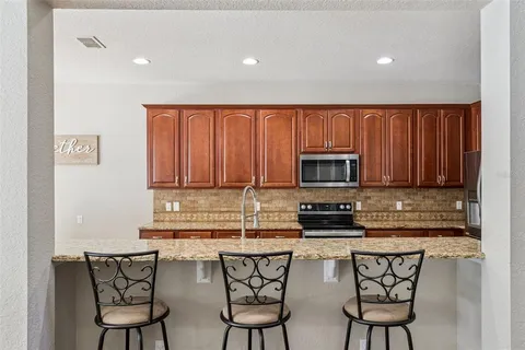 a kitchen with stainless steel appliances a stove a sink cabinets and a microwave
