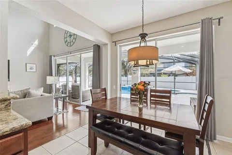 a dining room with furniture a chandelier and wooden floor