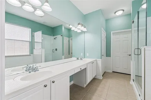 a spacious bathroom with a granite countertop sink a mirror and a shower