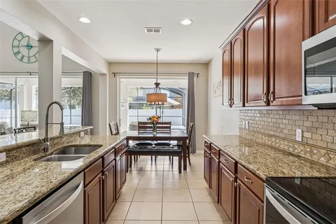 a kitchen with granite countertop a stove a sink and a refrigerator