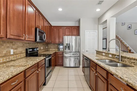 a kitchen with stainless steel appliances granite countertop a sink stove and refrigerator