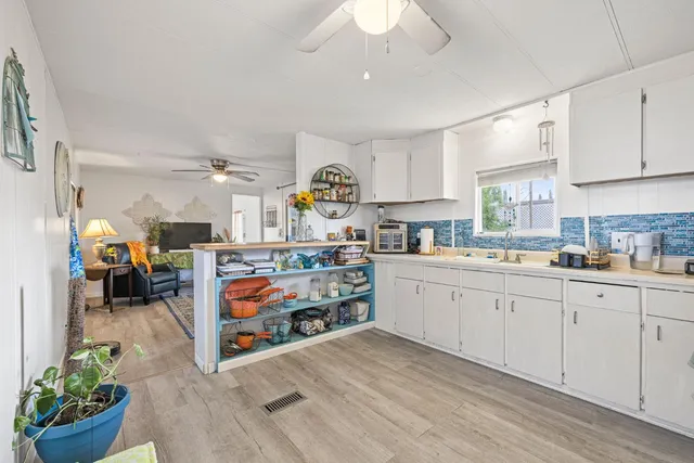 a kitchen that has a lot of cabinets and wooden floor