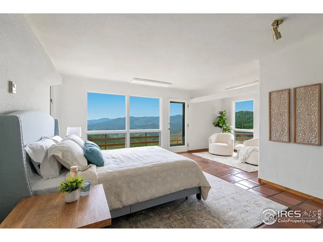 a bedroom with a large bed and a view of living room
