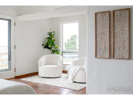 a bedroom with a bed and two large window