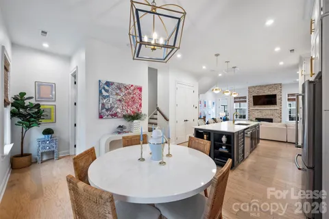 a large kitchen with kitchen island a stove a sink dishwasher and a dining table with wooden floor