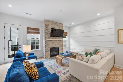 a living room with furniture a flat screen tv and a fireplace