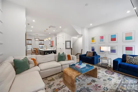 a kitchen with stainless steel appliances kitchen island granite countertop a stove a sink a refrigerator and a dining table with wooden floor