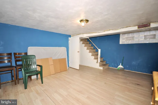 a view of an empty room with wooden floor and furniture