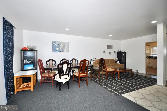 a living room with furniture a flat screen tv and a table