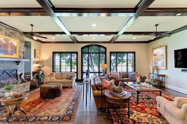 a living room with furniture a fireplace and large windows