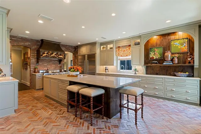 a kitchen with stainless steel appliances granite countertop a sink and a refrigerator